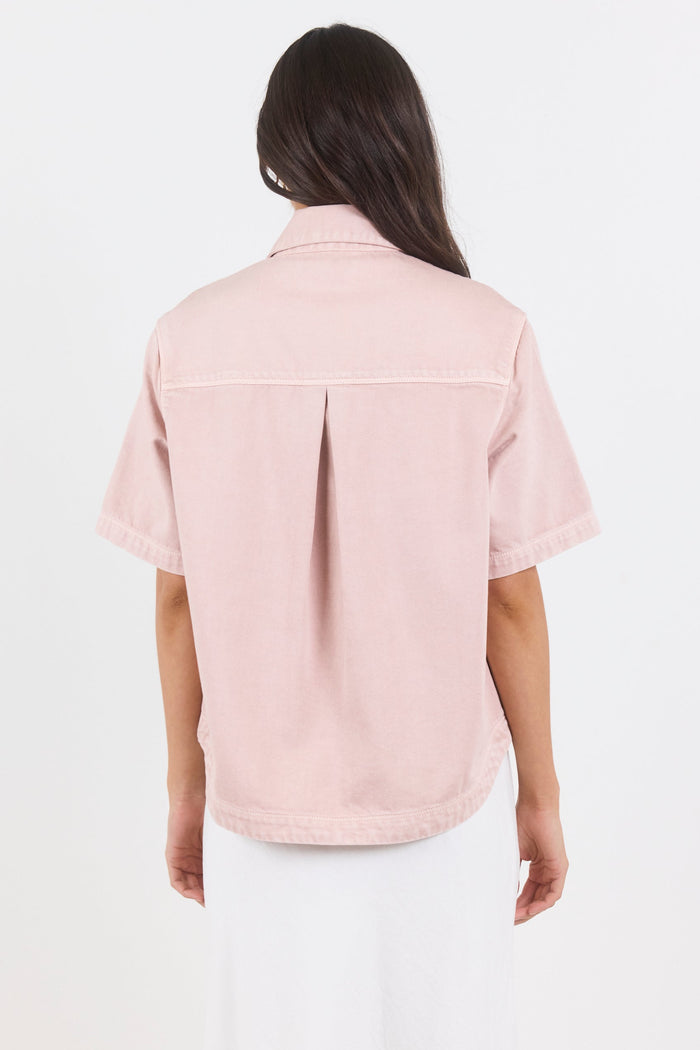 Person wearing a light pink shirt on a white background