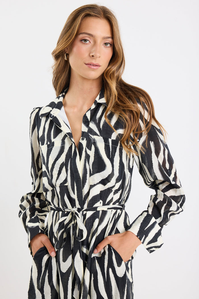 Woman wearing a zebra print dress against a white background