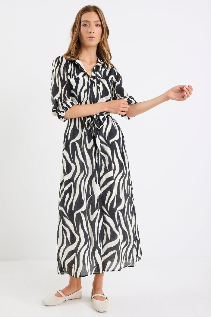 Woman wearing a black and white patterned dress on a white background