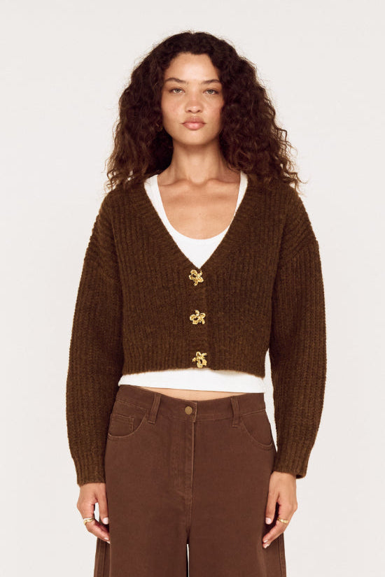 Woman wearing a brown cardigan and pants on a white background