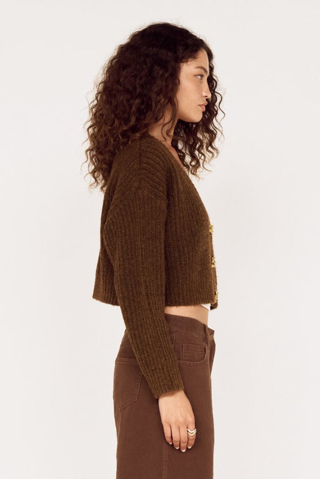 Woman wearing a brown outfit standing against a white background