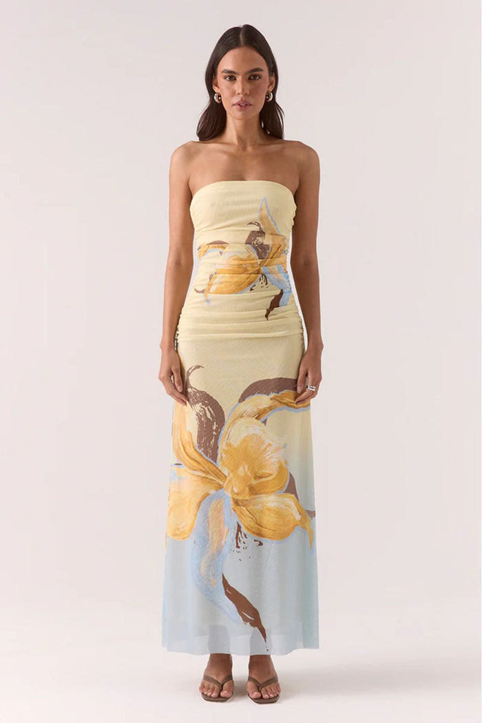 Woman wearing a strapless dress with a floral pattern on a white background