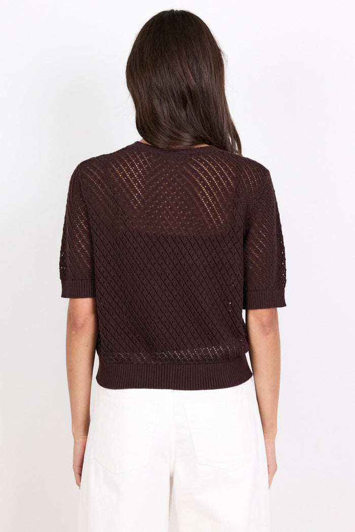 Woman wearing a brown textured top on a white background