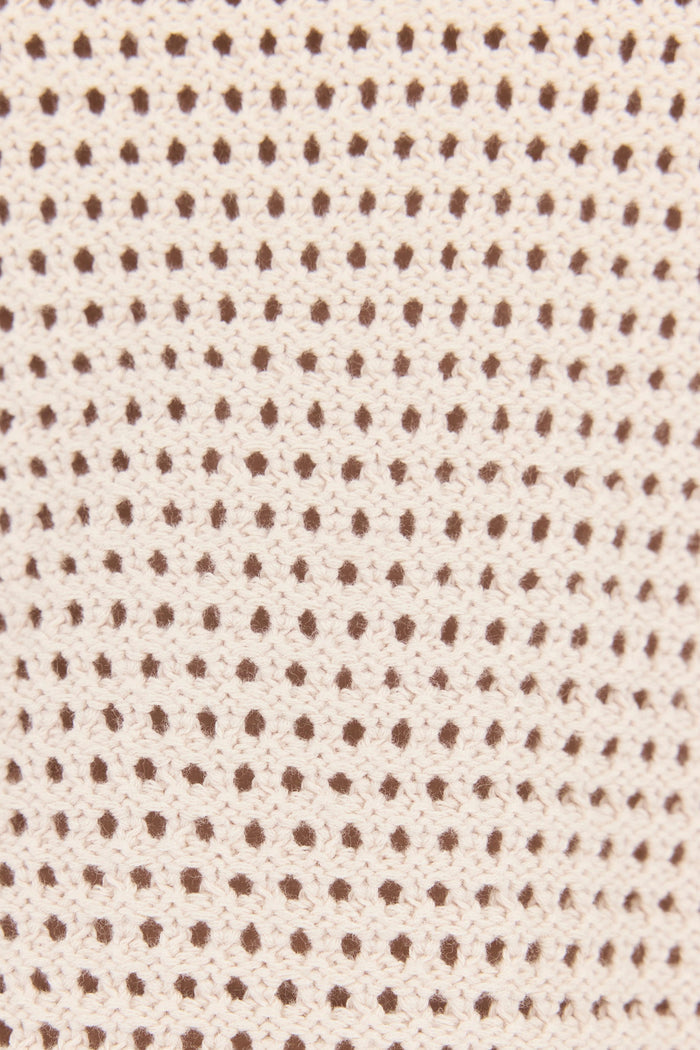 Textured fabric pattern with small brown dots on a beige background