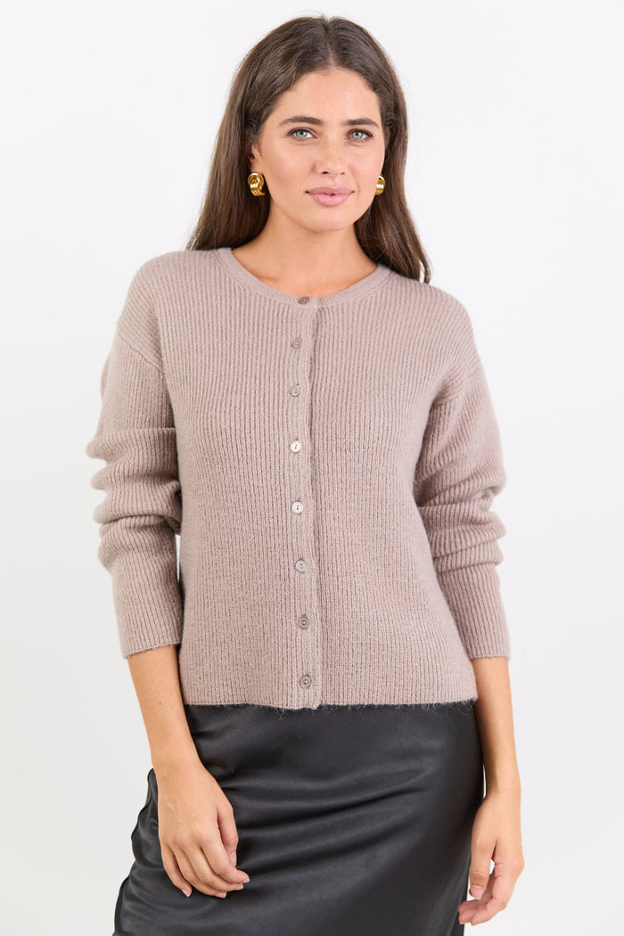 Woman wearing a beige cardigan on a white background