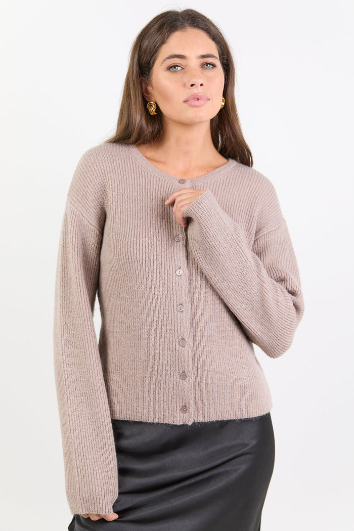 Woman wearing a beige cardigan on a white background