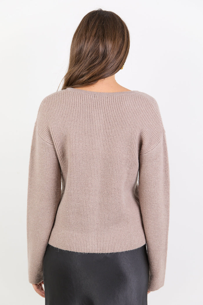 Woman wearing a beige sweater on a white background