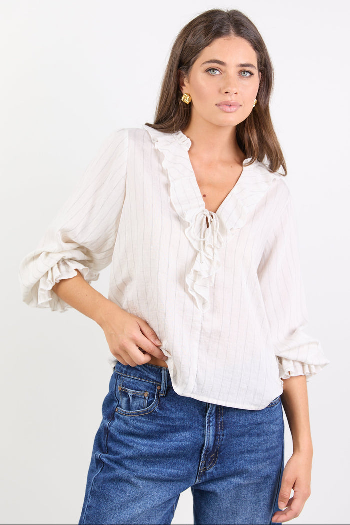Woman wearing a white blouse and blue jeans on a white background