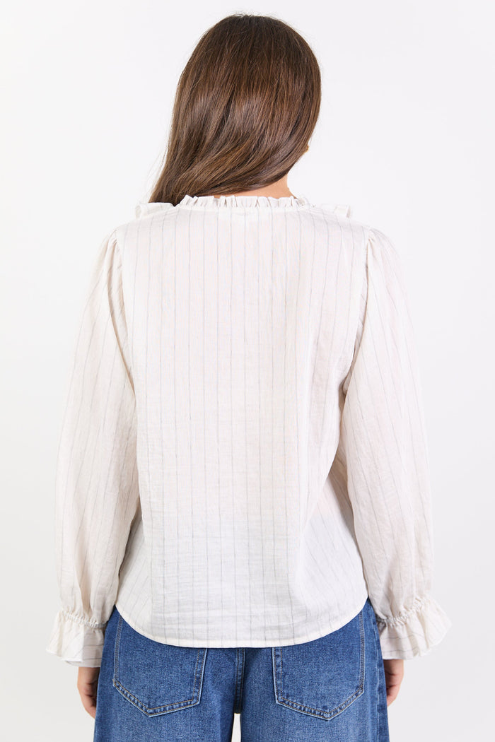 Woman wearing a white blouse and blue jeans on a white background