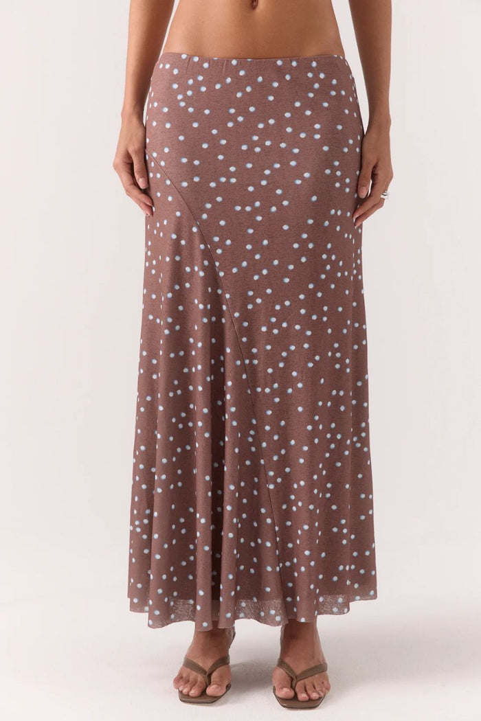 Woman wearing a brown and blue polka dot skirt and top set