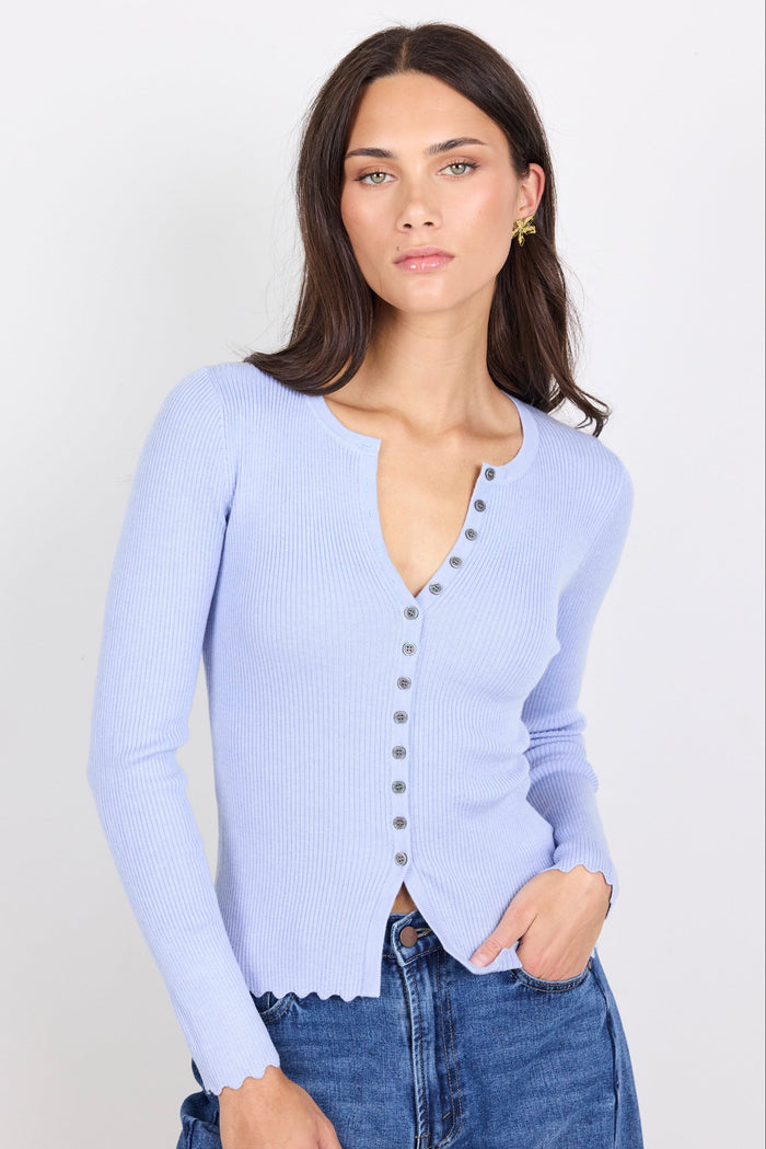 Woman wearing a light blue cardigan with a white background