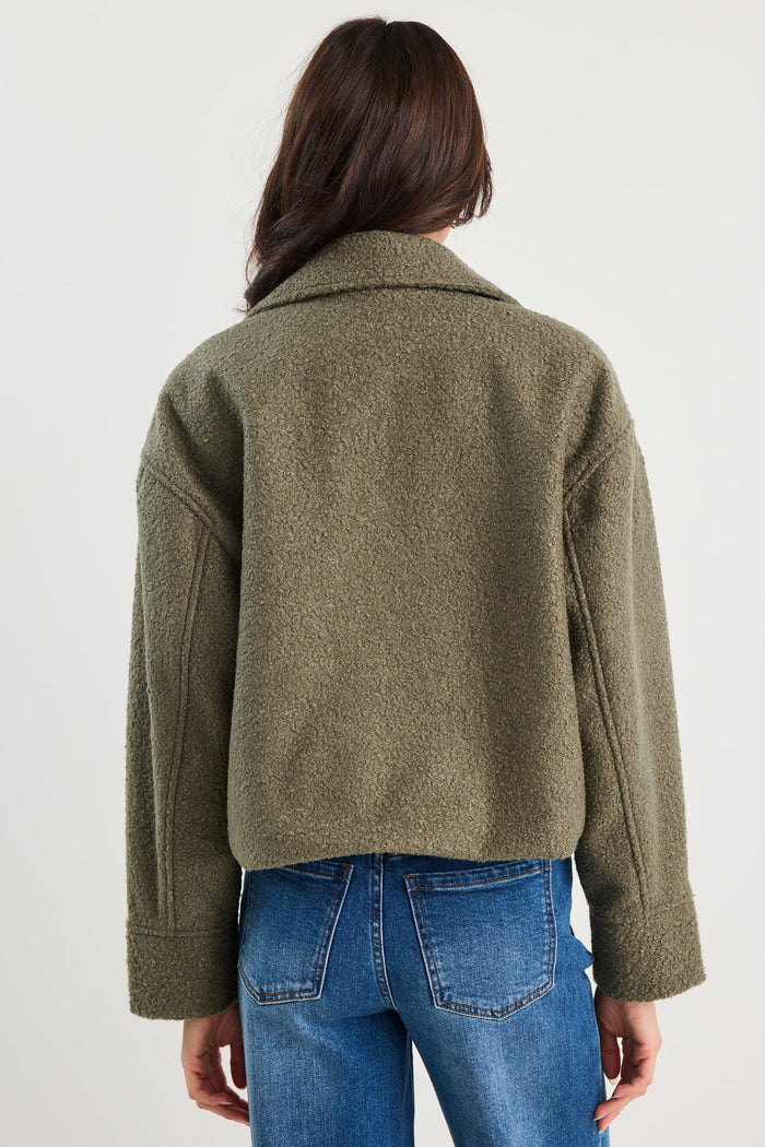 Person wearing a green jacket and blue jeans on a white background
col_pattern