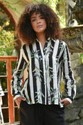 woman wearing a black white striped shirt with olive branches