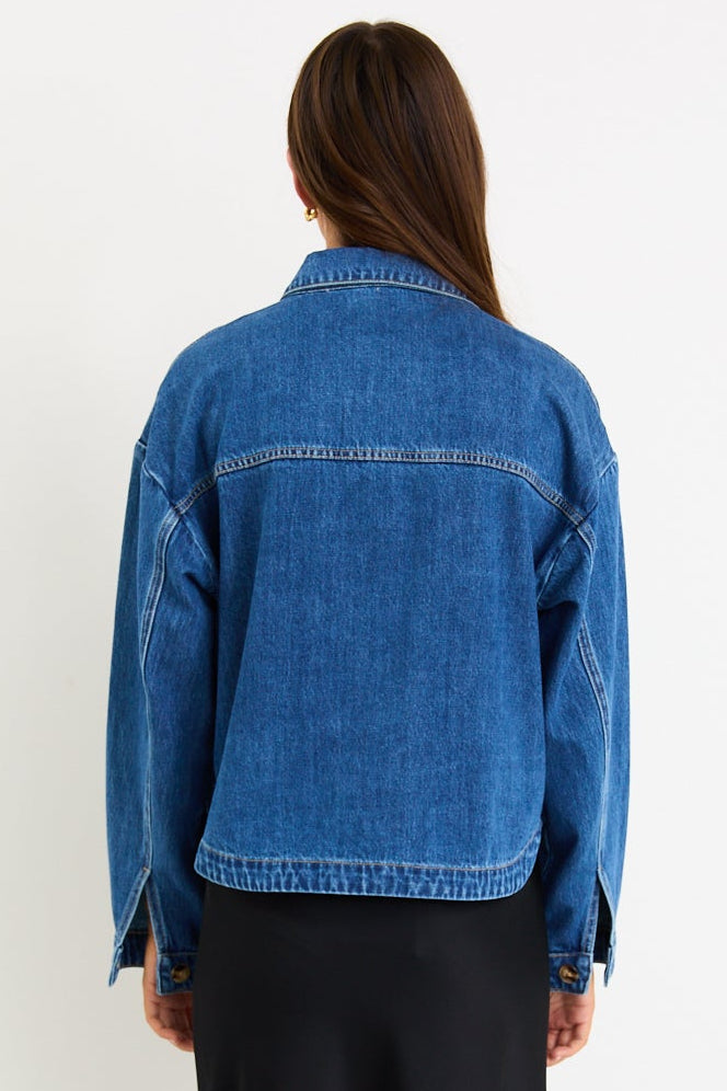 Person wearing a blue denim jacket and black skirt on a white background
@col_pattern