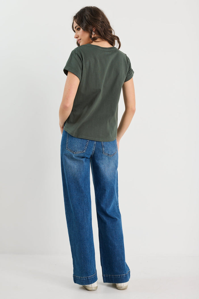 Person wearing a green t-shirt and blue jeans on a white background