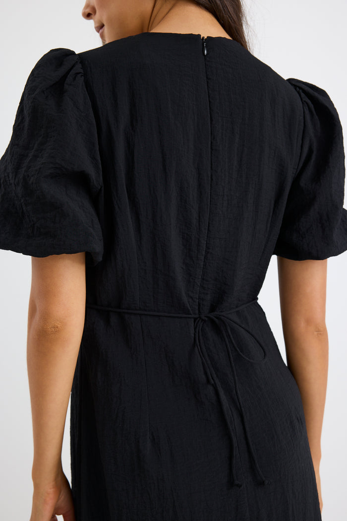 model wears a black puff sleeve midi dress