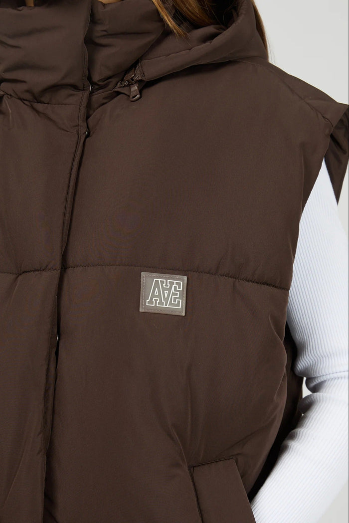 Brown puffer vest with a brand logo on a neutral background