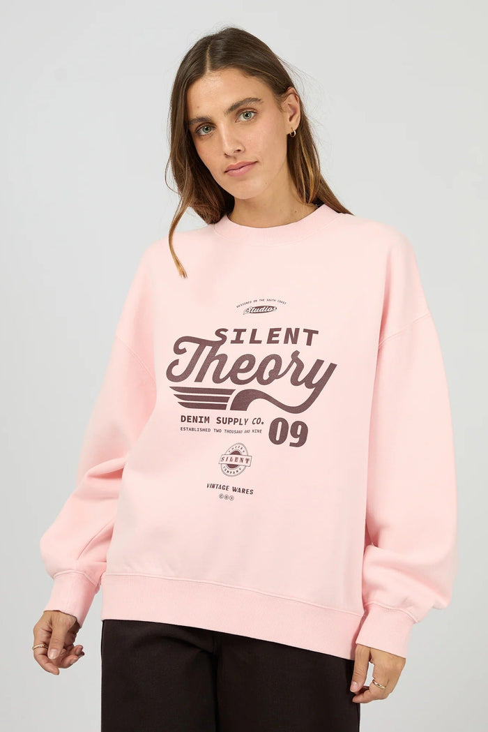 Person wearing a pink sweatshirt with 'Silent Theory' print on a gray background