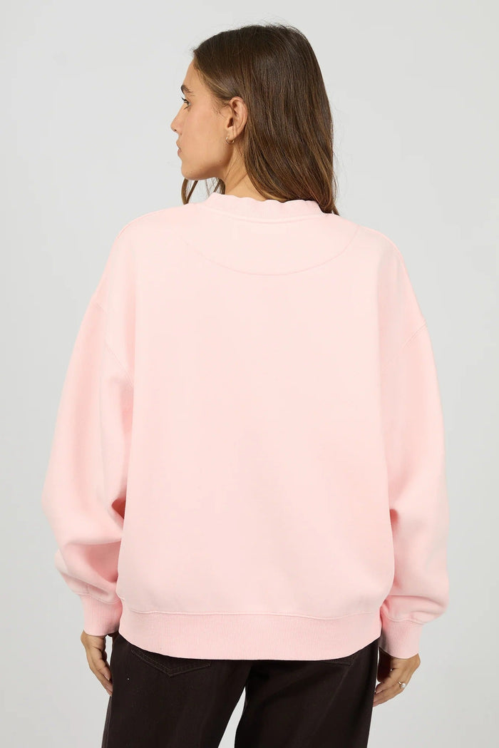 Person wearing a light pink sweatshirt on a plain background