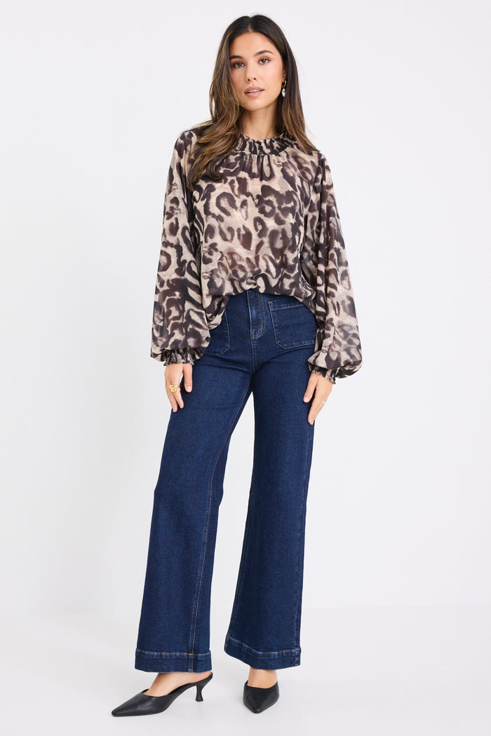 model wears a white and black animal print blouse