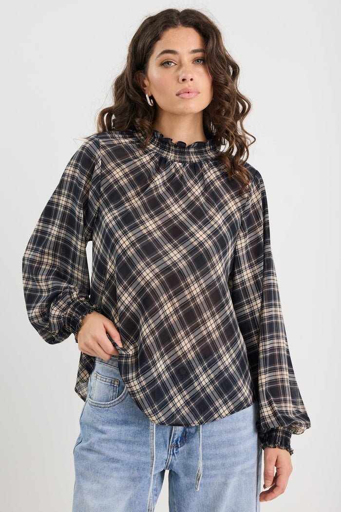 Woman wearing a plaid shirt and jeans on a white background