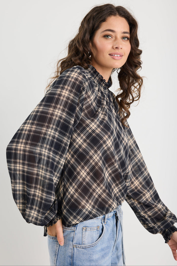 Woman wearing a plaid shirt and jeans on a white background