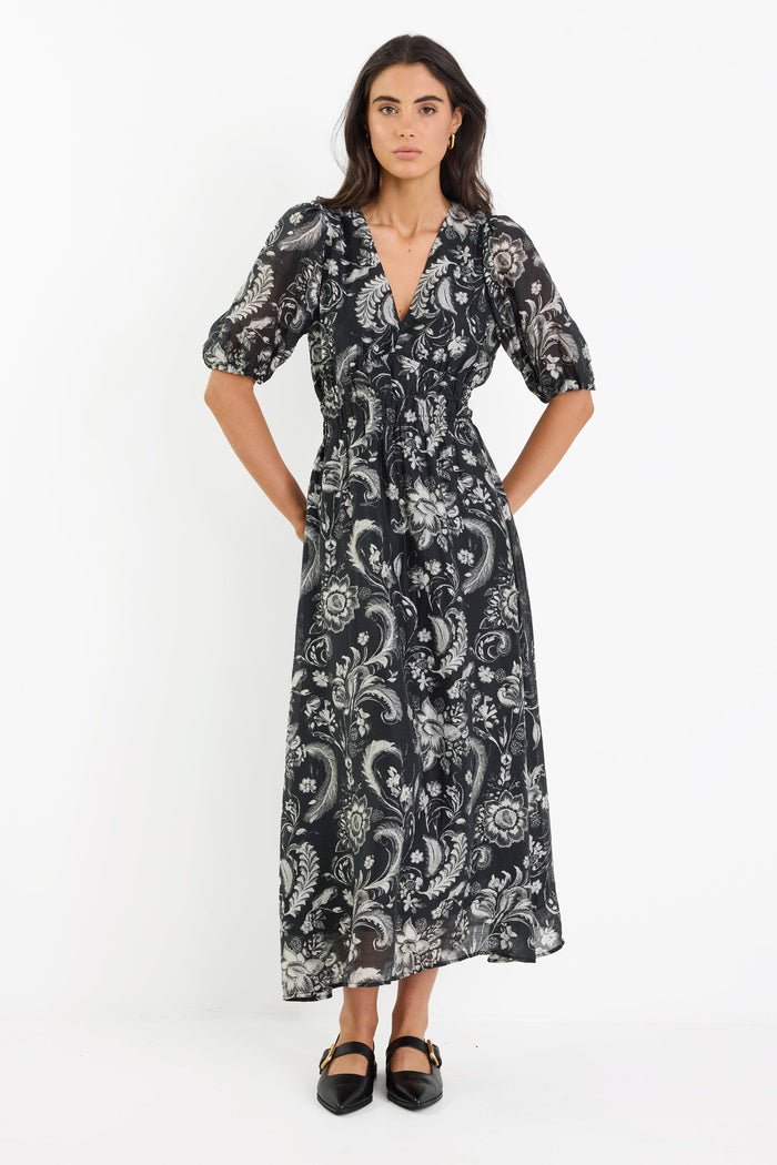 Woman wearing a black and white patterned dress on a white background