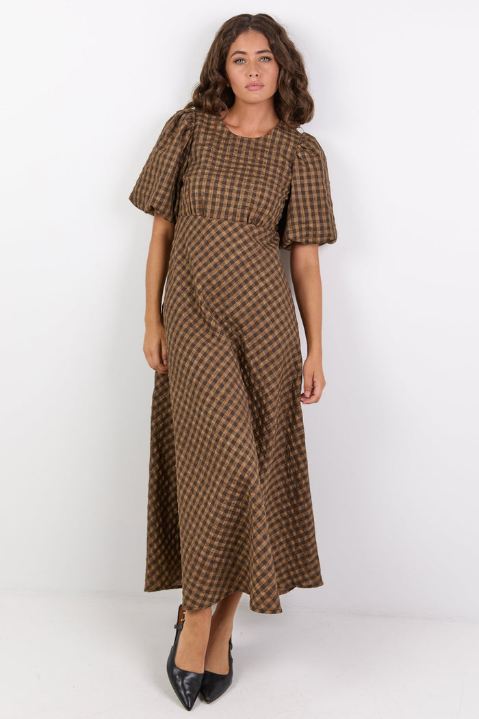 Woman wearing a brown checkered dress on a white background