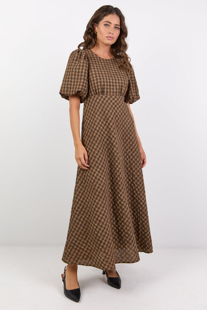Woman wearing a brown checkered dress on a white background