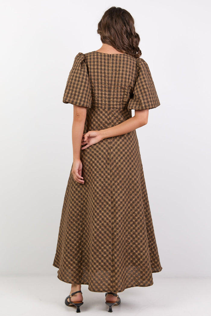 Woman wearing a brown checkered dress on a white background