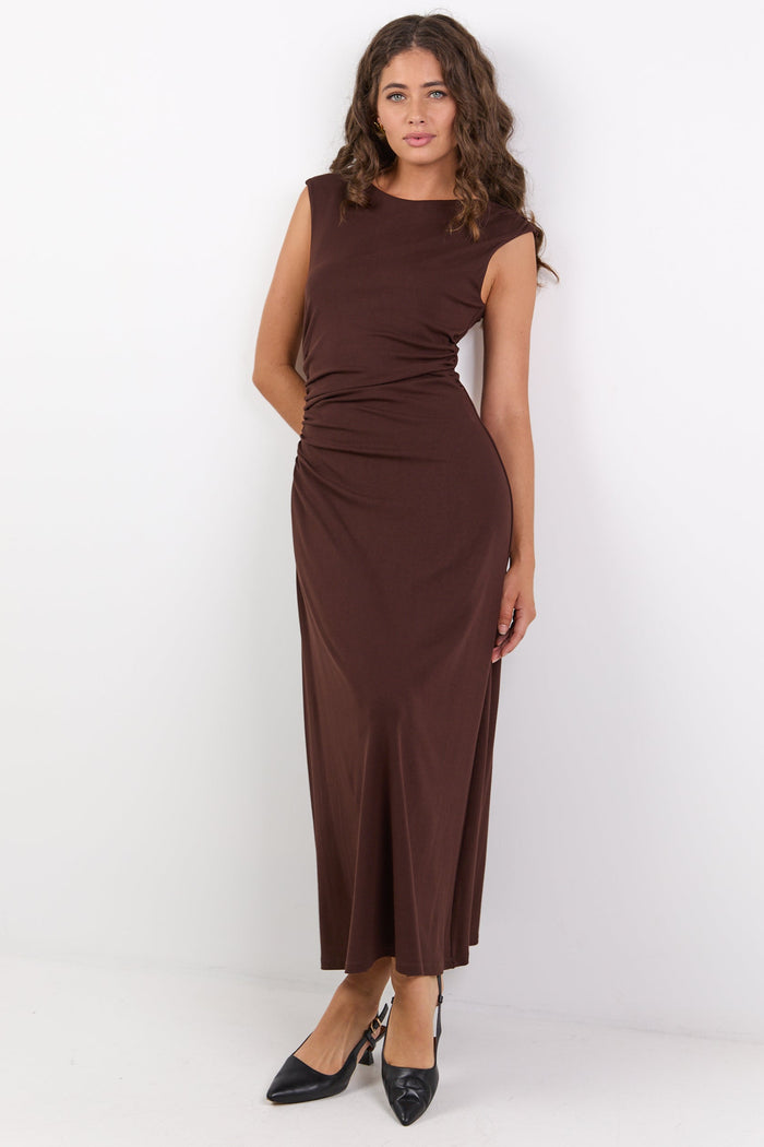 Woman wearing a brown dress against a white background