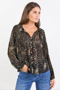 Woman wearing a patterned blouse and blue jeans on a white background