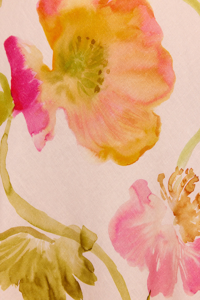 A close-up of a watercolor floral pattern featuring large pink, yellow, and orange flowers with green stems on a pale blush background.