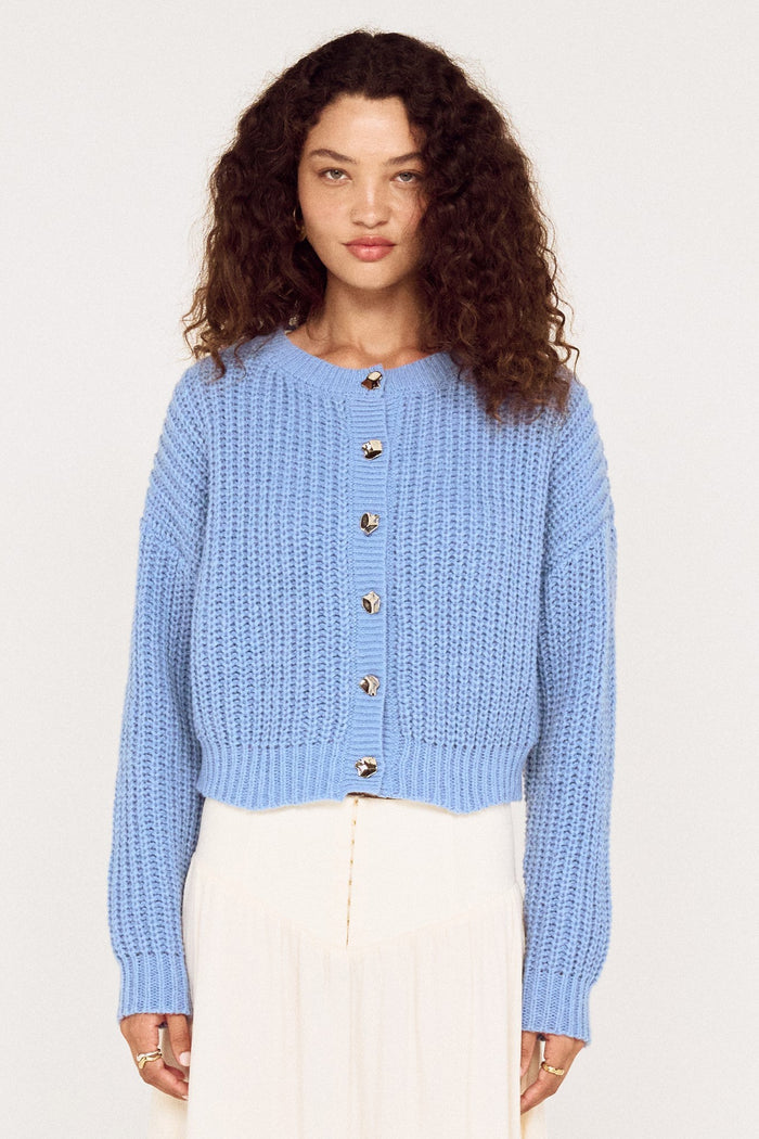 Woman wearing a light blue knitted cardigan on a white background