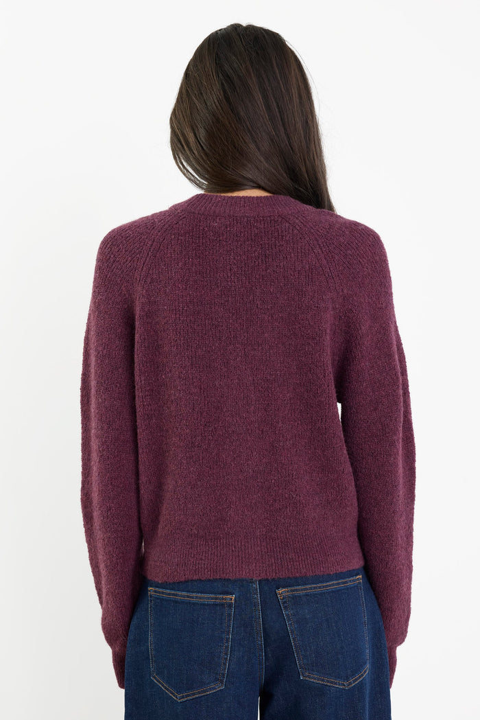 Person wearing a maroon sweater and blue jeans on a white background
col_pattern