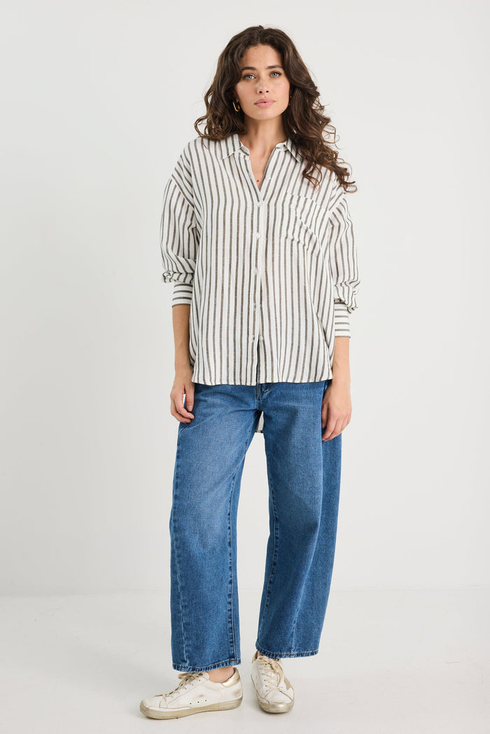 Woman wearing a striped shirt and blue jeans on a white background