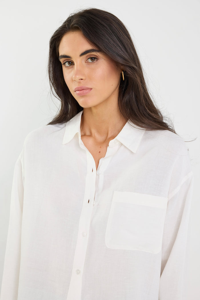 Woman wearing a white shirt against a plain background