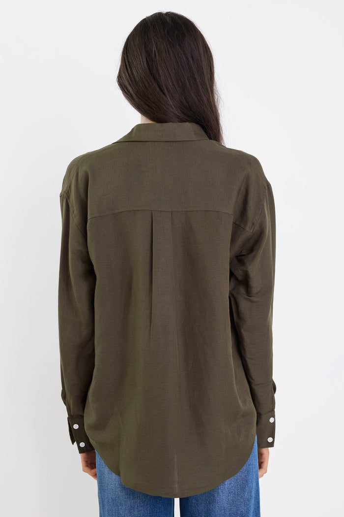 Person wearing an olive green shirt and blue jeans on a white background