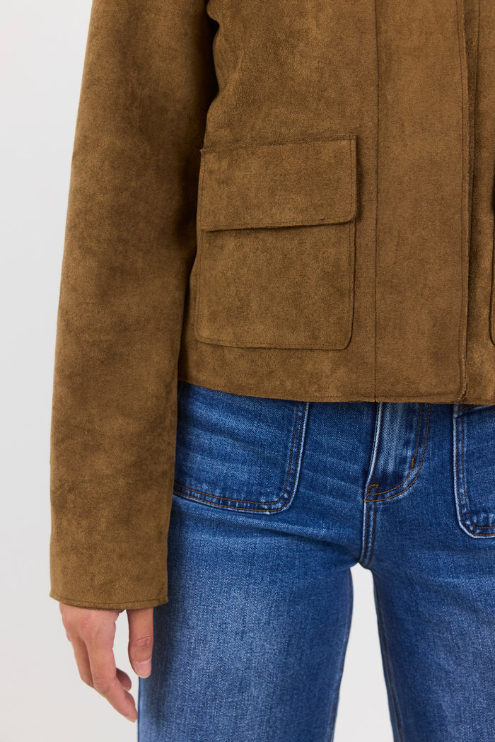Brown suede jacket and blue jeans on a white background