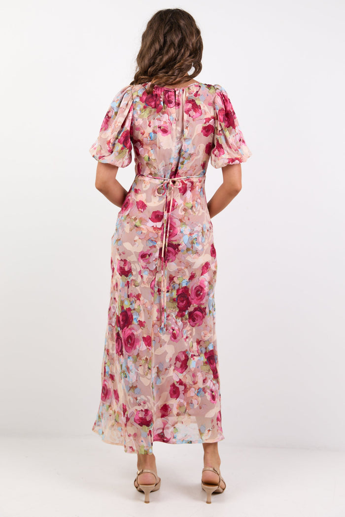 Woman wearing a floral dress from behind on a white background