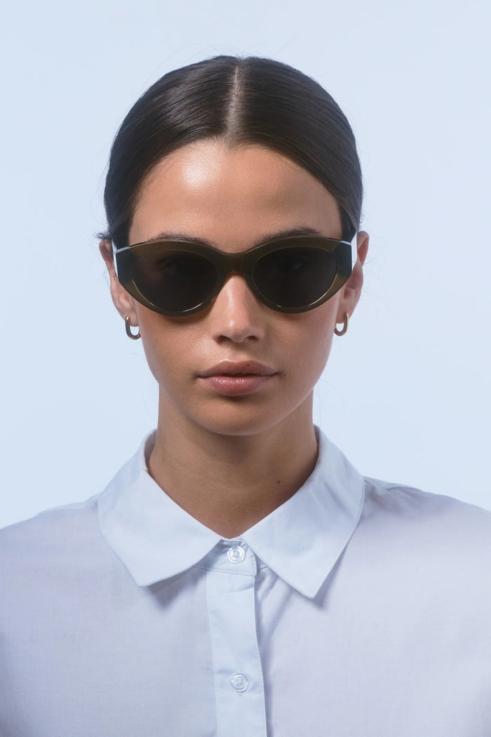 Person wearing dark sunglasses against a light background