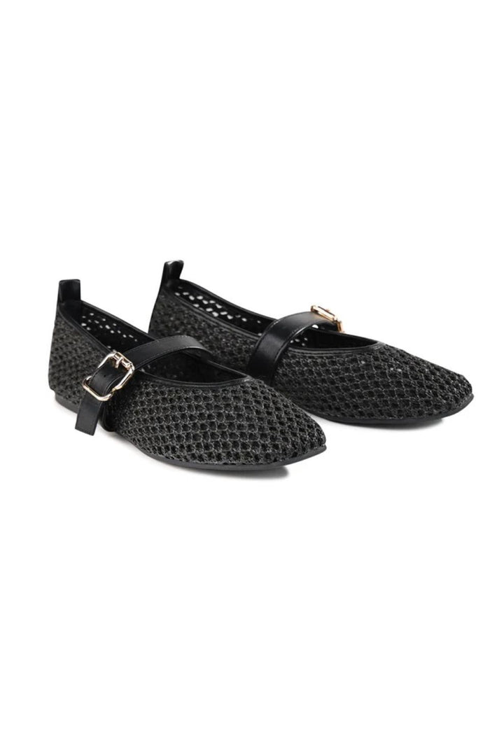 A pair of black pointed-toe flats with a textured, openwork mesh-like upper and a thin strap across the instep with a small gold-tone buckle, shown on a plain white background.
