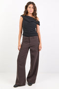 Woman wearing a black top and brown pants on a white background