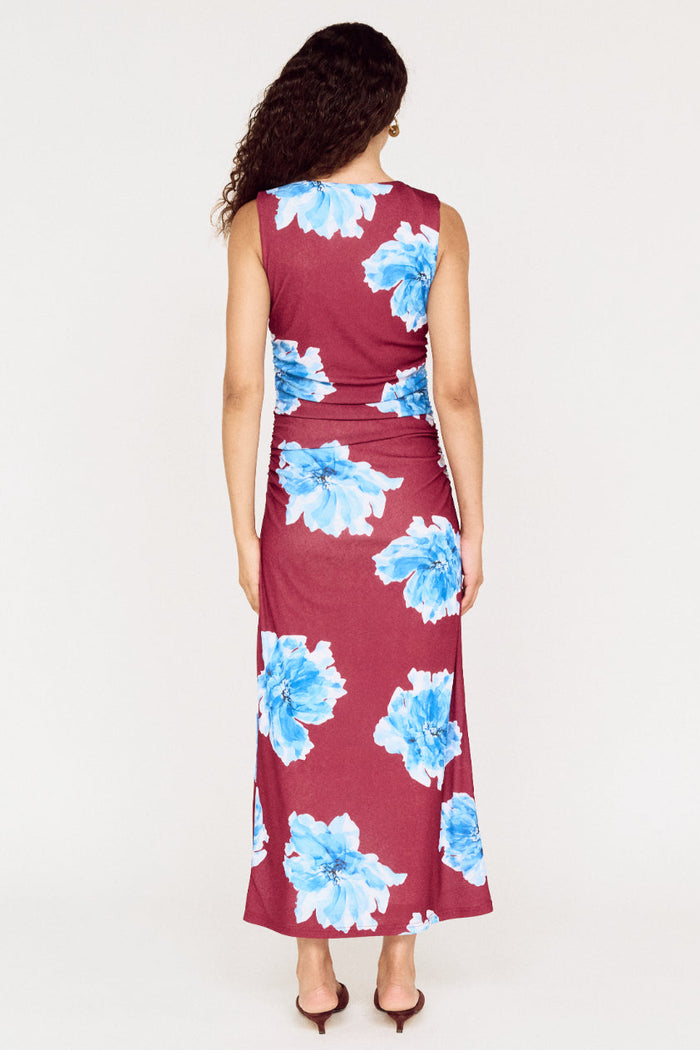 Woman wearing a burgundy dress with blue floral pattern on a white 
background
col_pattern