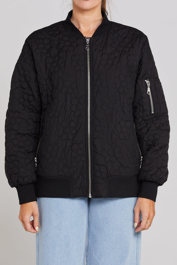 Model wears black quilted bomber jacket