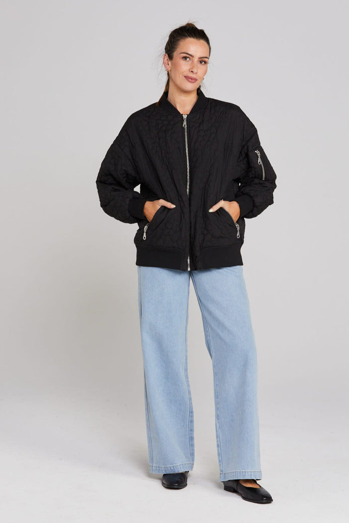 Model wears black quilted bomber jacket