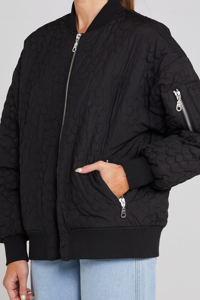 Model wears black quilted bomber jacket