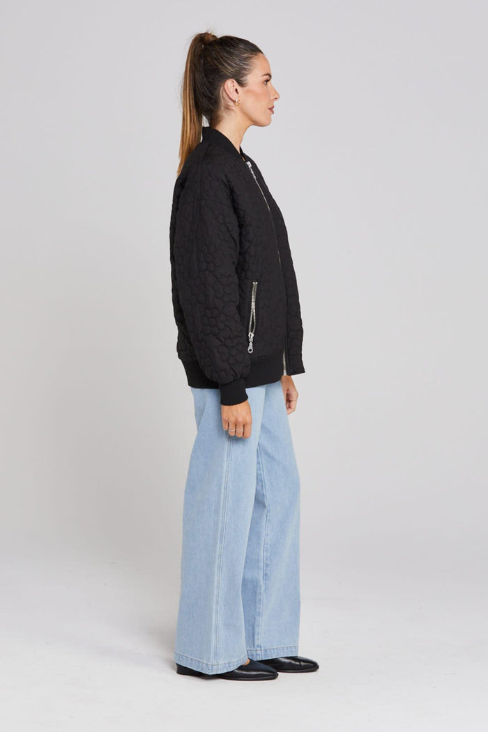 Model wears black quilted bomber jacket