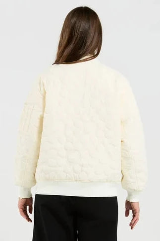 Person wearing a light-colored sweater and black pants on a white background