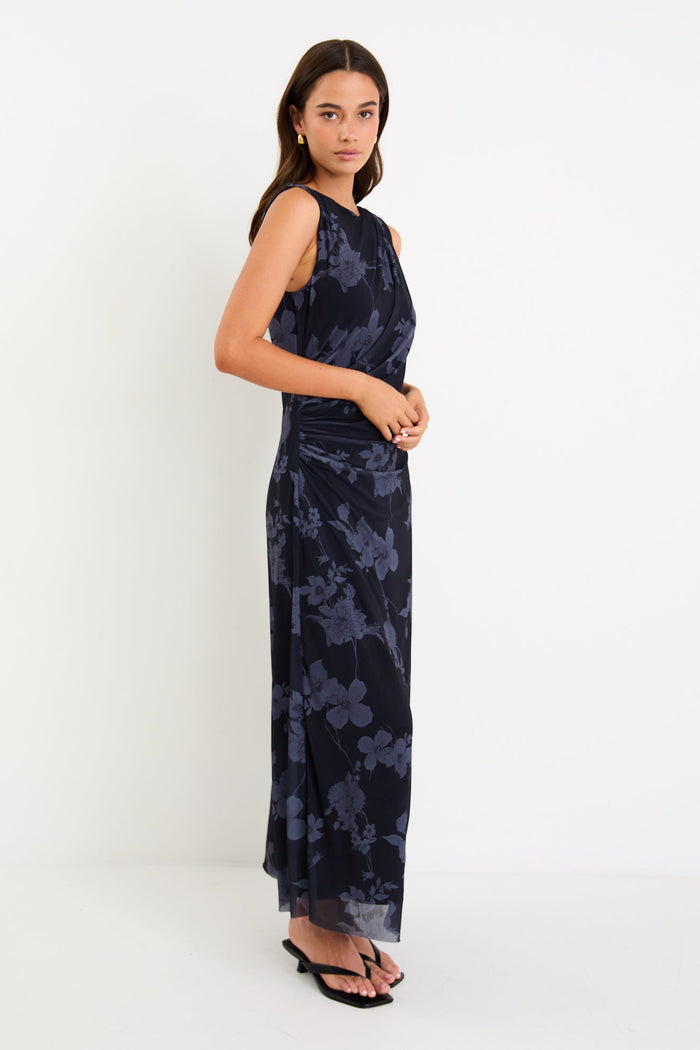 Model wearing a sleeveless midnight floral mesh maxi dress with gentle gathering at the waist and a slim, draped silhouette.